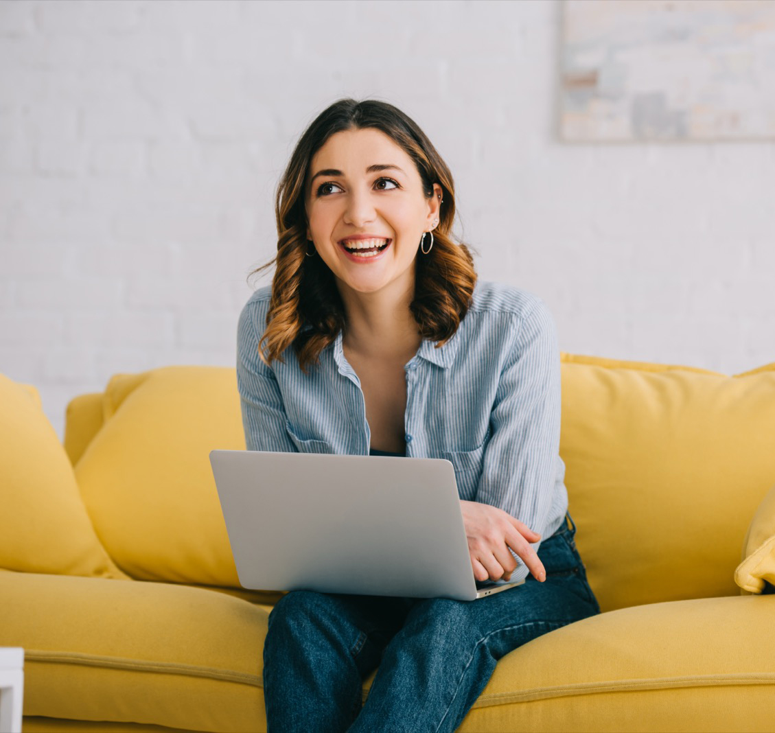 Woman using Lext on her laptop from the comfort of her sofa